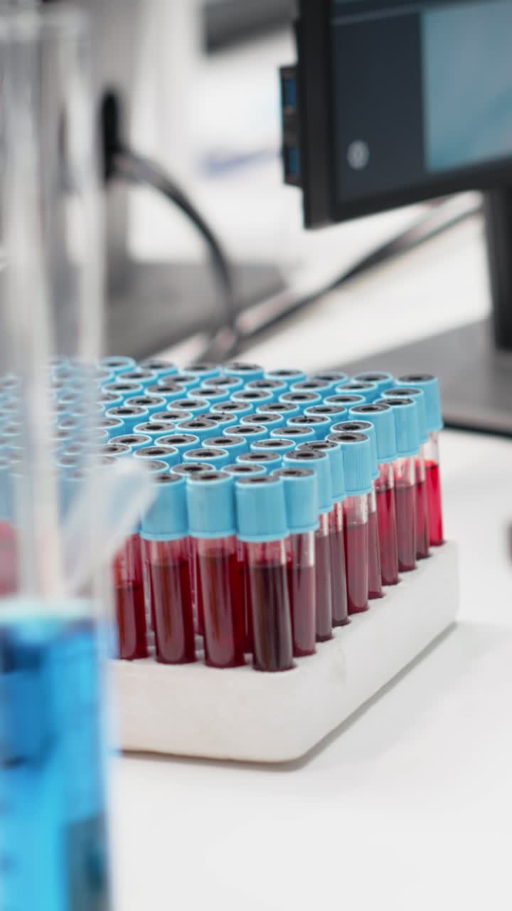 Vertical video Close up of colorful chemical solutions inside scientific glassware on lab shelf