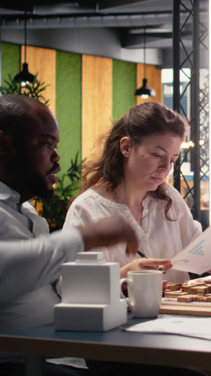 Vertical Video Team members work together in office with architectural software