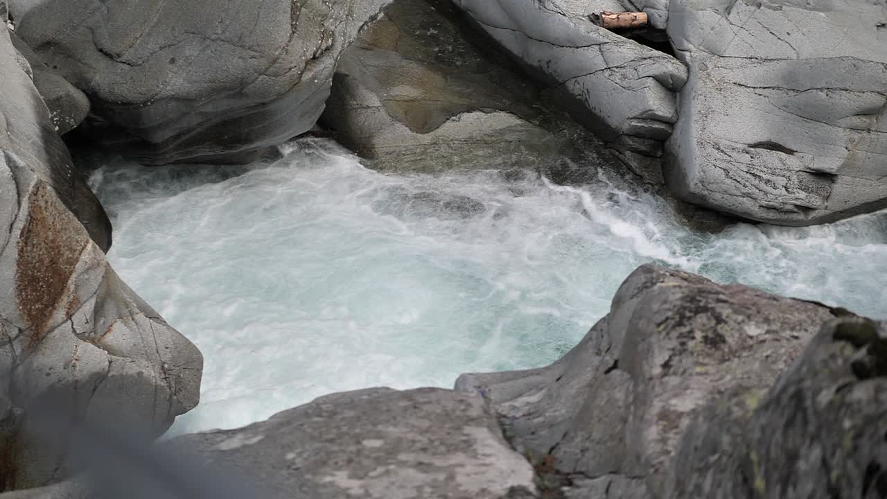 Clear water streaming true the rocks and falling down on a small waterfall in Lauterbrunnen Switserland. Slowmotion shot
