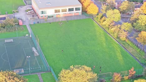 A-drone-shot-of-a-soccer-pitch-with-football-being-played-at-a-leisure-facility