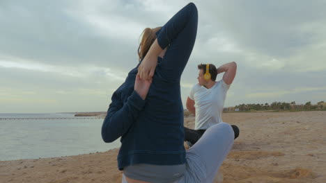 young people in headphones working out by the sea