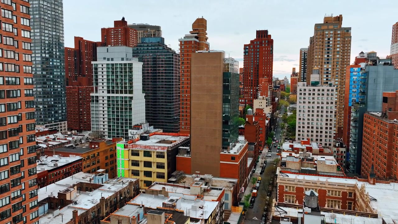 Volando tra i grattacieli nel centro della metropoli. Architettura densa a New York, USA, di giorno.