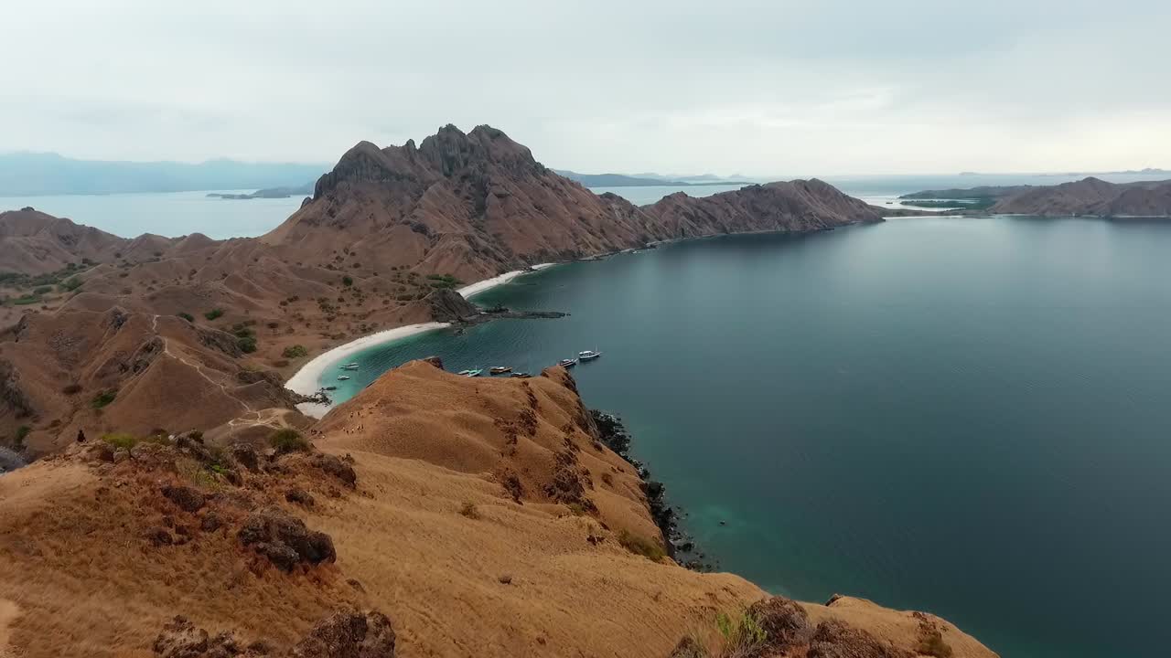 vista aérea desde la isla de padar, hacia los barcos en la costa de komodo, indonesia - dolly, drone shot
