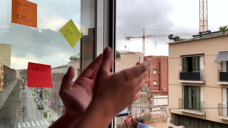 Young woman clapping her hands at a window