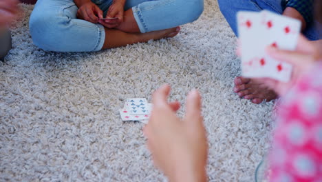 group of friends at home playing cards together