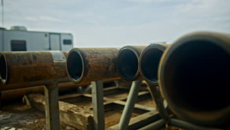 moving along the metal pipes set outdoors in a row. materials and constructions for oil and gas drilling. close up.