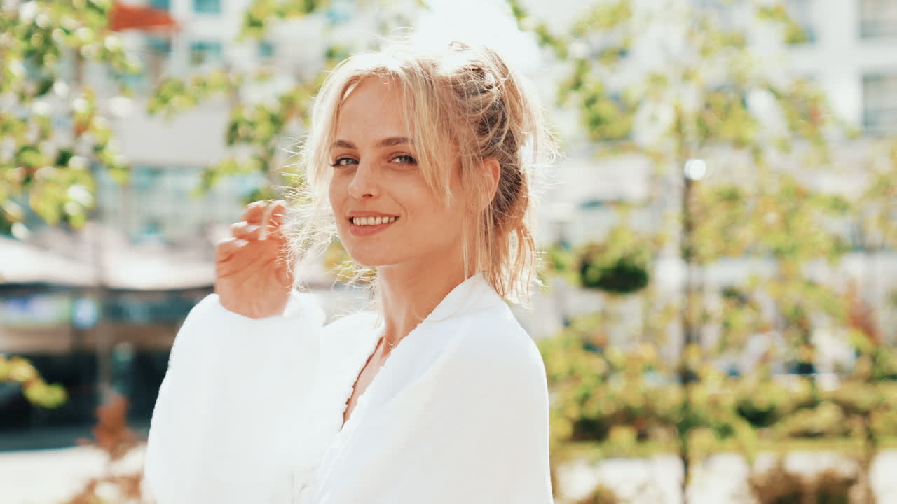 망토 를 입은 여자 가 야외 에서 미소 짓고 있다