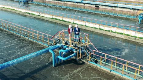 two businessmen talking on the bridge at a cleaning facility. water management concept.