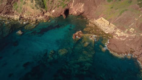 Stunning-aerial-of-rugged-cliff-coastline-with-Laveria-Lamarmora-ruins-in-Nebida