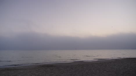 Empty sandy beach by the calm sea just before dawn