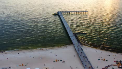 aerial top view of sea bridge in palanga, lithuania during sunset - drone shot