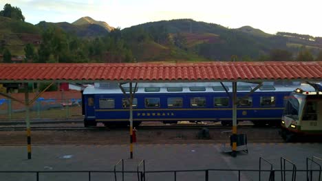 pedestal drone shot at a train station in poroy with carriages waiting to depart to machu picchu, peru