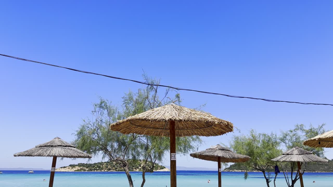 Ombrelloni sulla spiaggia pulita Bandiera Blu della penisola Calcidica, Grecia.