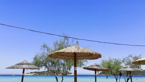 Umbrellas-on-the-clean-blue-flag-beach-of-Halkidiki-Peninsula,-Greece