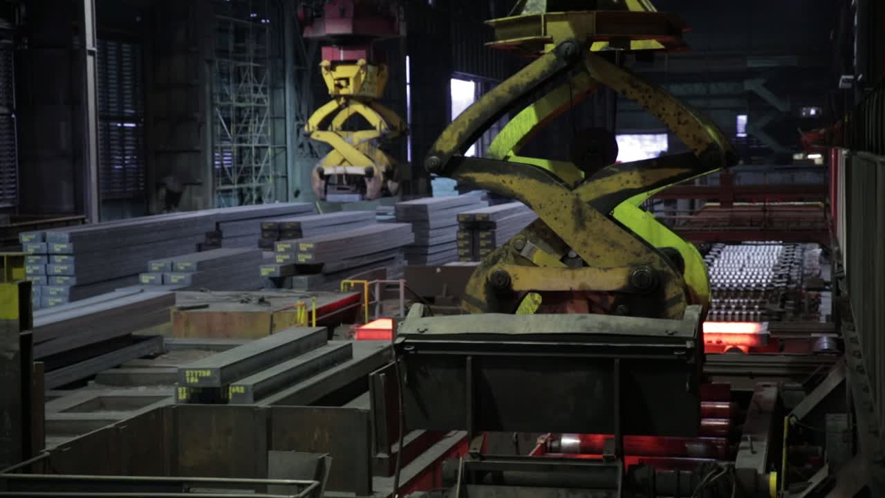 brazos robóticos industriales que manejan metal brillante en una fábrica de acero, maquinaria de resaltado de luz ambiental y barras de acero