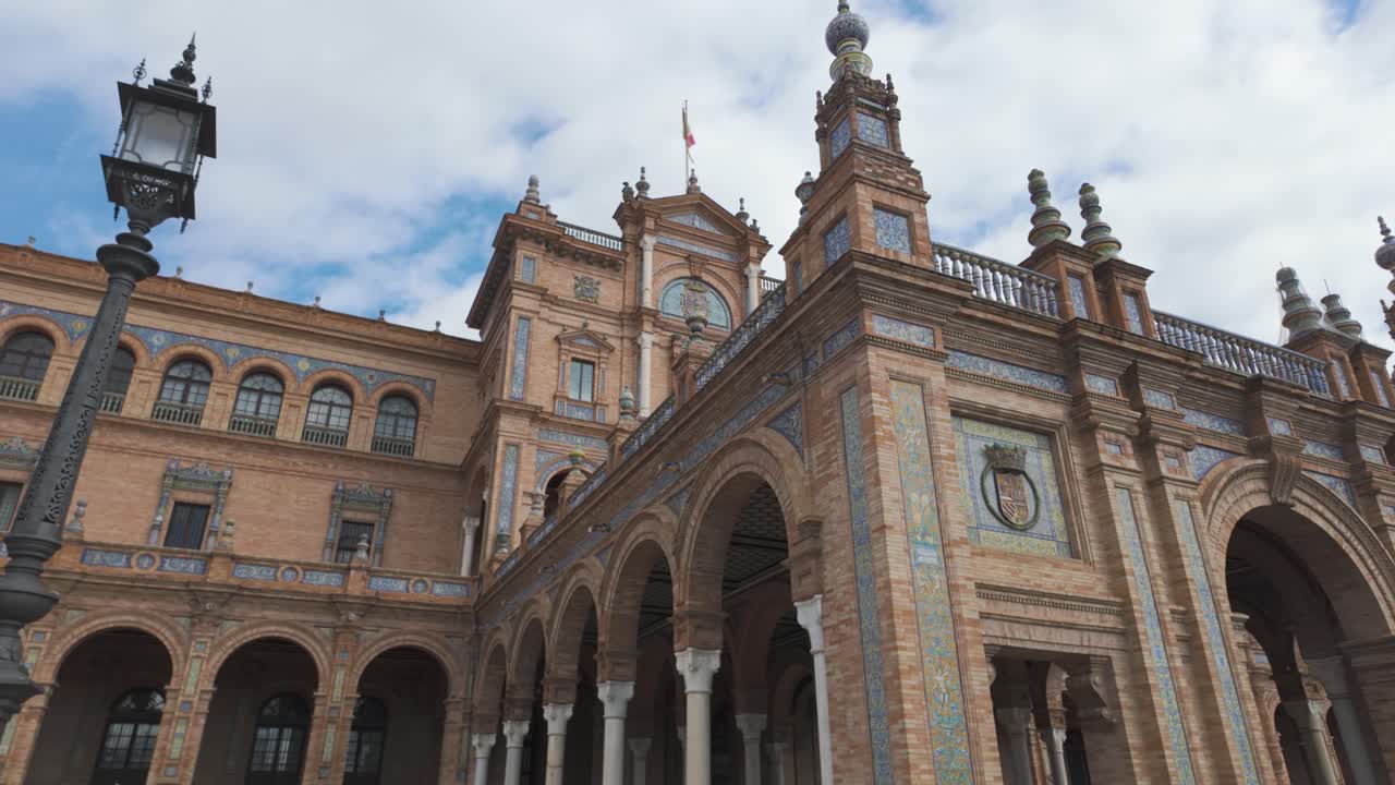 Majestic architecture and detailed arches of Plaza de España in Seville under a cloudy sky