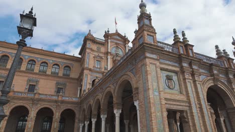 majestic architecture and detailed arches of plaza de españa in seville under a cloudy sky