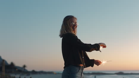 Teenagermädchen-Tanzt-Mit-Wunderkerzen-Am-Strand-Bei-Sonnenuntergang,-Feiert-Silvester-Und-Hat-Spaß-Bei-Der-Unabhängigkeitstagsfeier-Mit-Feuerwerk-Und-Genießt-Die-Freiheit