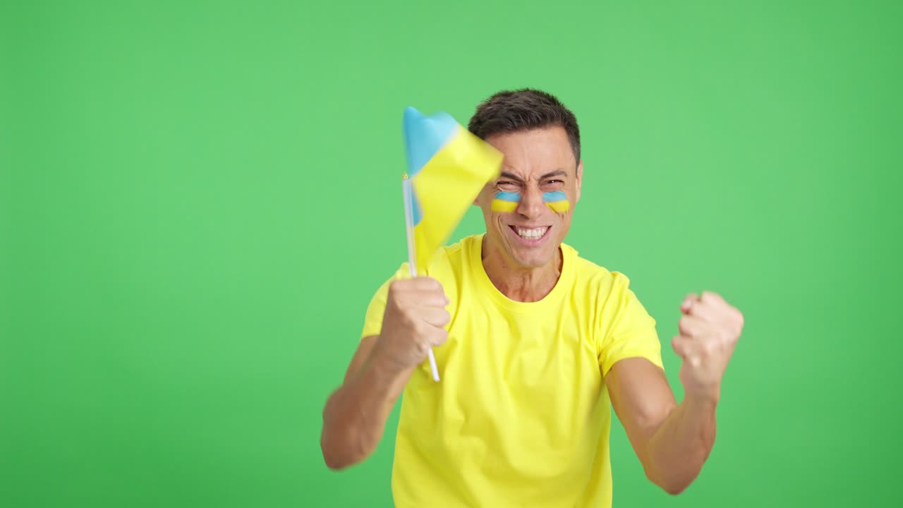 Passionate ukrainian supporter screaming and waving a national flag