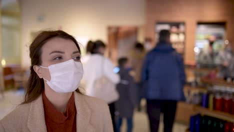 beautiful girl wearing protective medical mask and fashionable clothes looks around