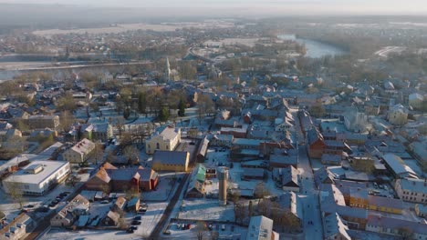 aerial establishing view of kuldiga old town , houses with red roof tiles, sunny winter day, travel destination, wide drone shot moving forward