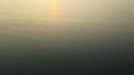 hermosa mosca aérea de drones sobre las aguas brillantes de color naranja del lago seneca nueva york al atardecer