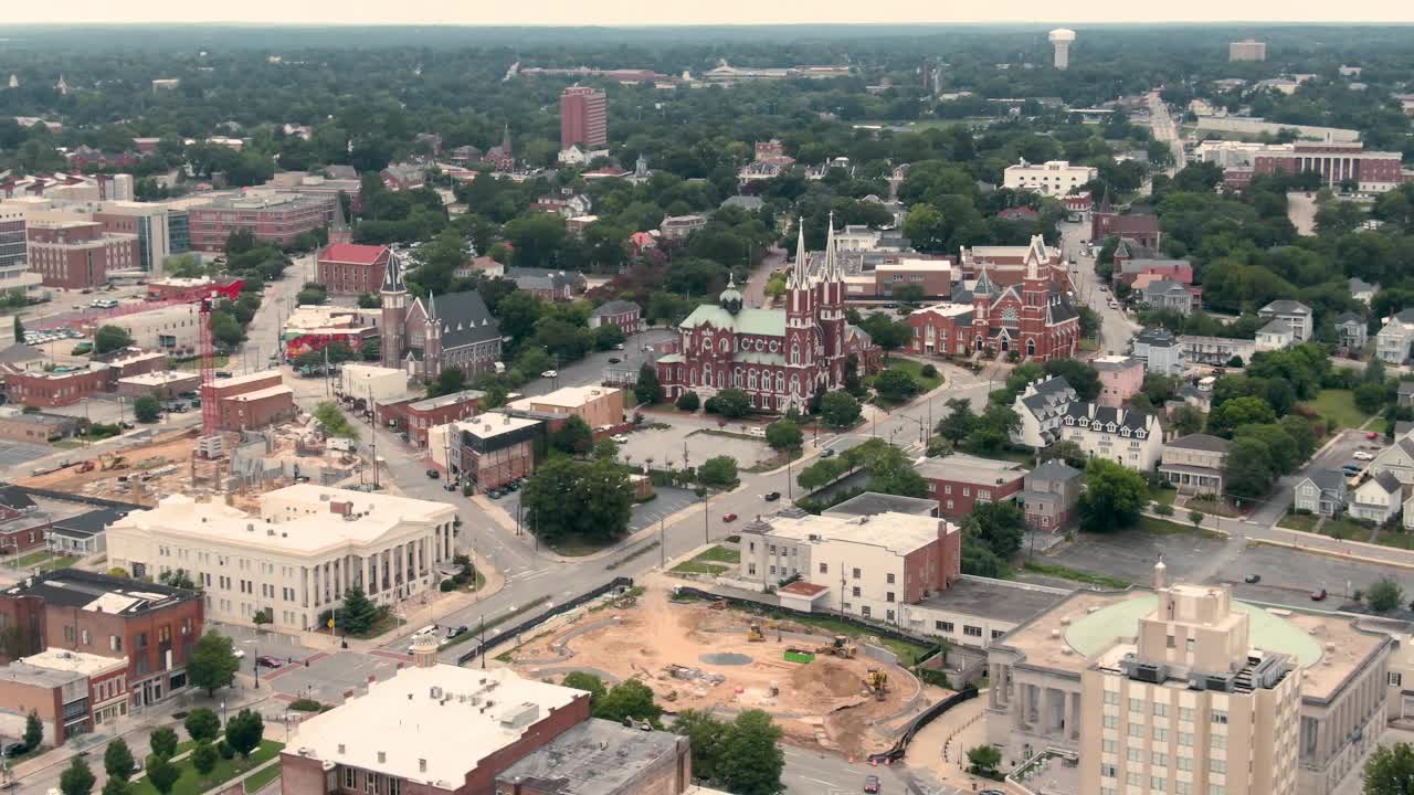 An aerial view of the St. Joseph Church in Macon, Georgia, with construction sites in the foreground. The church is a preserved Neo-Gothic masterpiece in a modernizing southern city