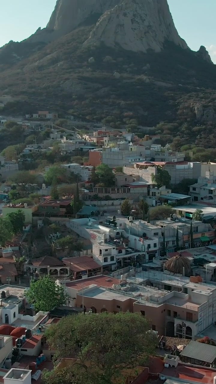 Ripresa con drone che rivela la montagna Peña de Bernal a Querétaro, Messico, sorvolando la città di Bernal