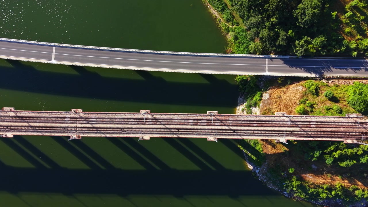 Ponti attraversano un fiume con acqua limpida e vegetazione verde sotto un cielo luminoso durante il giorno.