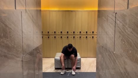 hombre millennial asiático rico desnudándose en un lujoso vestuario