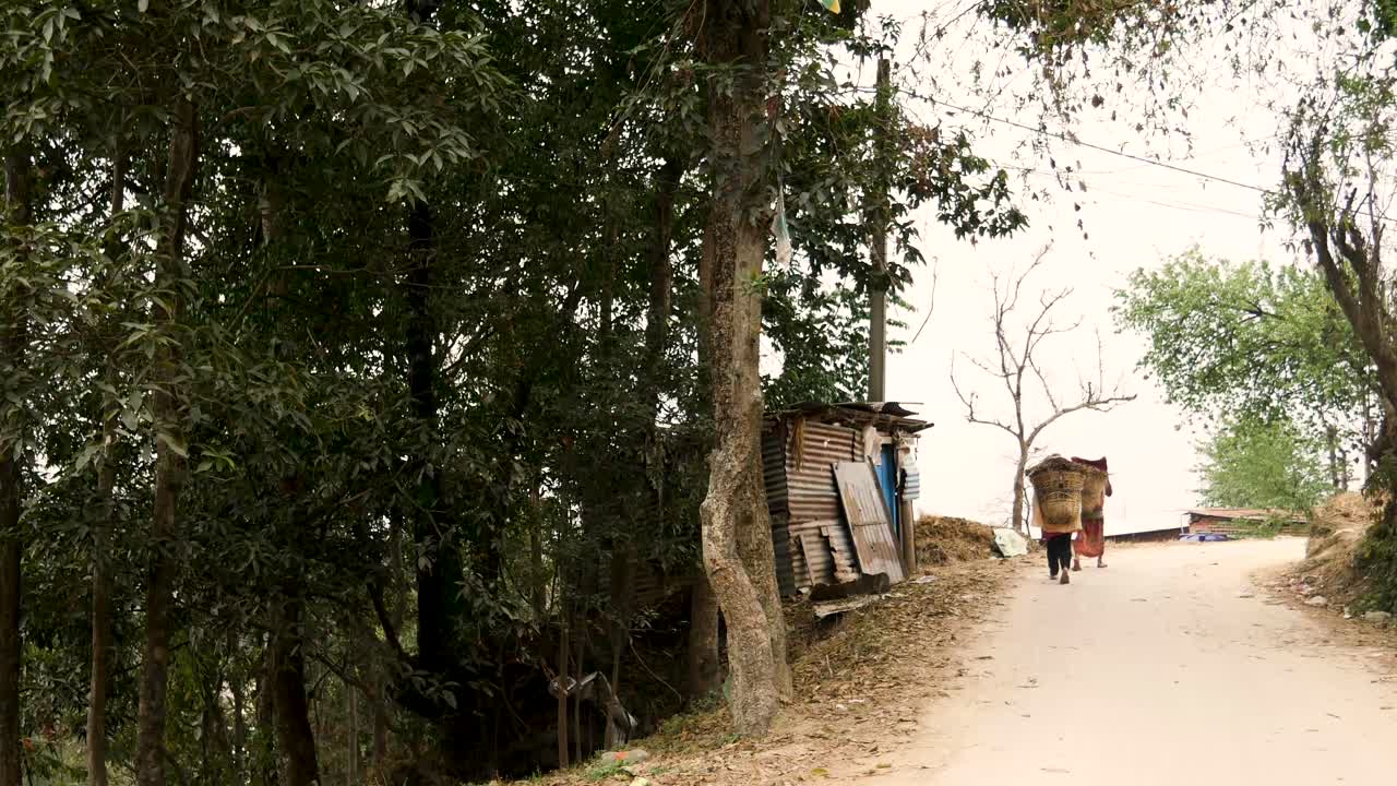personas cargando materiales en un doko en las zonas rurales de nepal