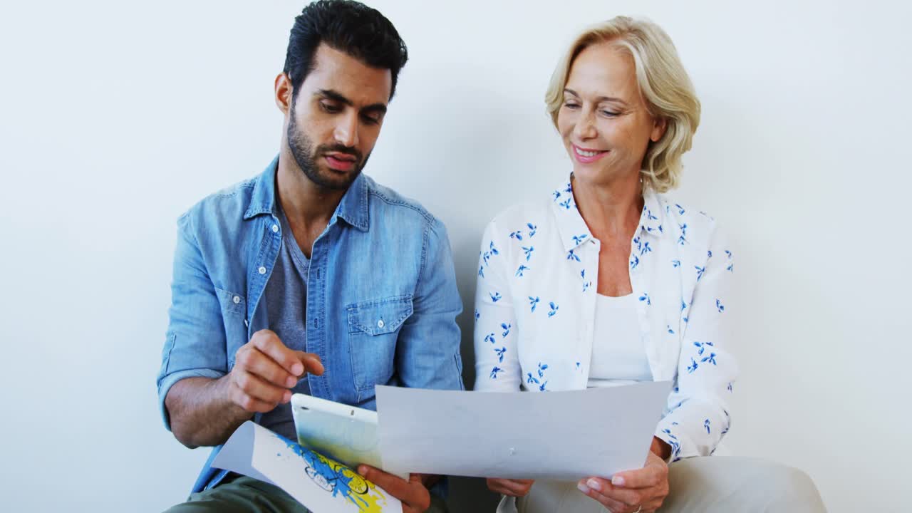 ejecutivos masculinos y femeninos discutiendo sobre una tableta digital