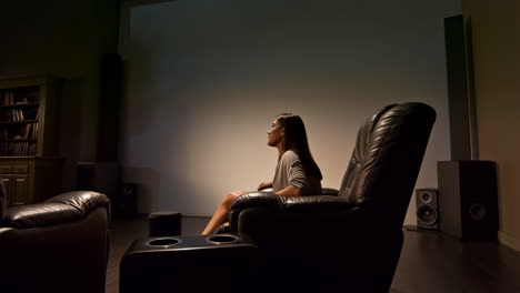 woman watching a movie in a dark home theater