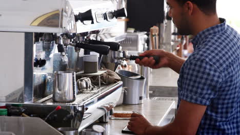 un joven barista preparando un espresso en una cafetería
