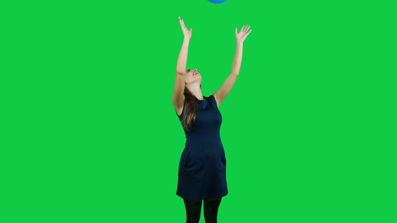 Girl playing with the balloon in front of a green screen