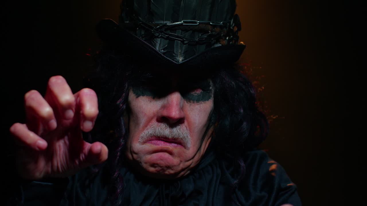 hombre maduro senior siniestro en disfraz de carnaval de halloween brujo haciendo caras, tratando de asustar