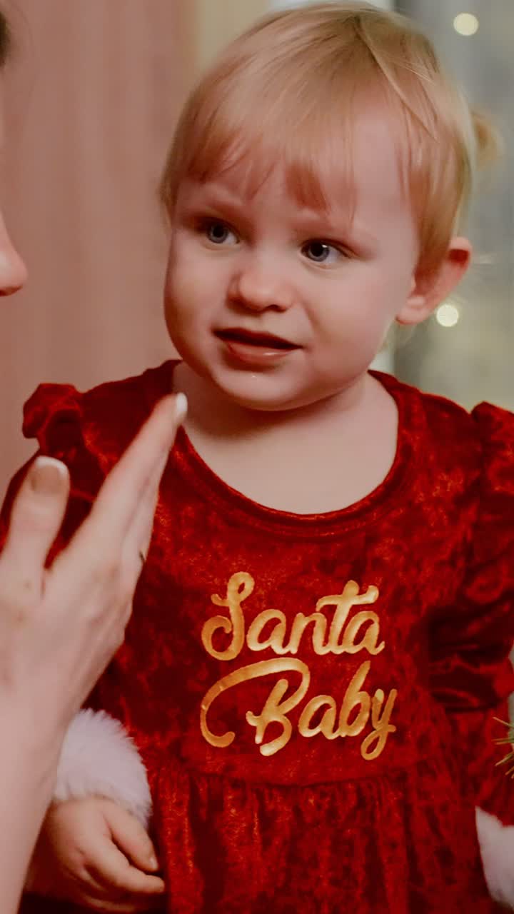 A Joyful Child in a Festive Red Outfit Delicately Interacts with Holiday Decorations, Capturing the Essence of Holiday Cheer and Wonder in Each Magical Moment as They Celebrate the Season