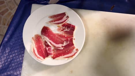 person cuts meat into tiny slices