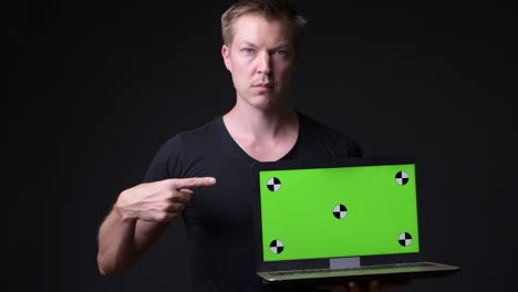 man holding laptop with chroma key green screen