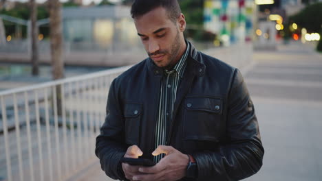 young man using smartphone and walking outdoors.