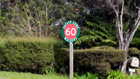 un cartel verde y rojo en la carretera que indica la zona de seguridad y el límite de velocidad del automóvil de 60 km/h, en la popular ruta de senderismo de nueva zelanda, aotearoa