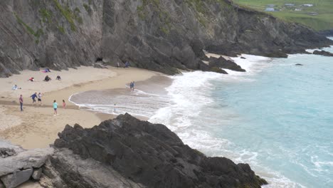 tourists enjoying at coumeenoole beach, republic of ireland - wide shot