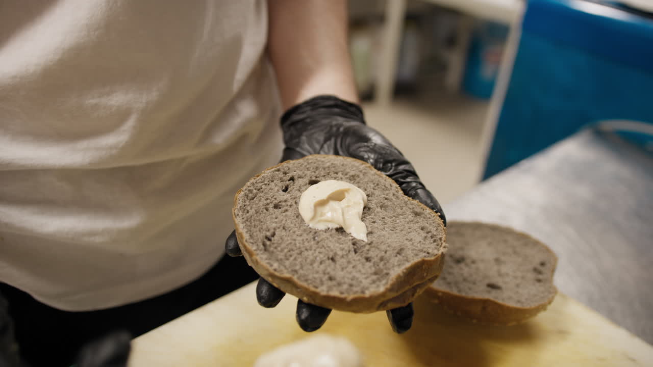 Chef Using Spoon To Spread Mayonnaise On The Wholemeal Bread For The Burger