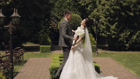 Lovely-newlyweds-caucasian-bride-groom-walking-in-park,-holding-hands,-wedding-couple-family