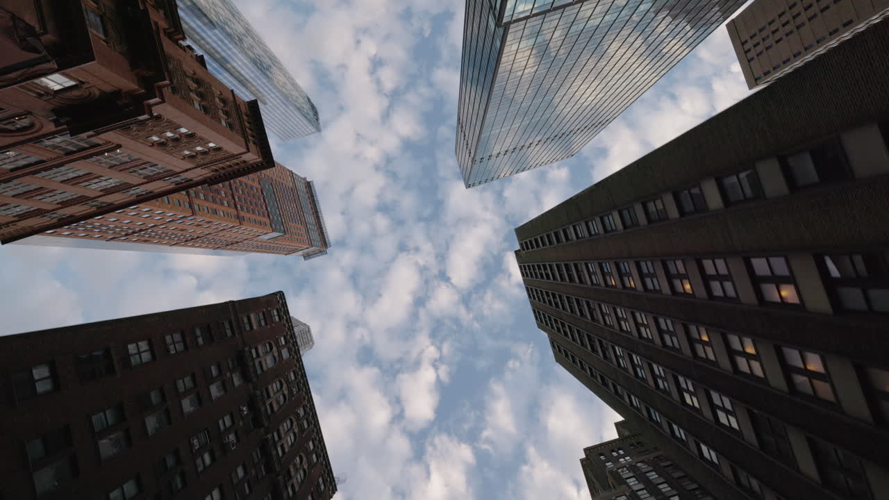 Vista de baixo ângulo de arranha-céus e céu nublado em Manhattan, Nova York. Arquitetura urbana e perspectiva dramática da cidade.