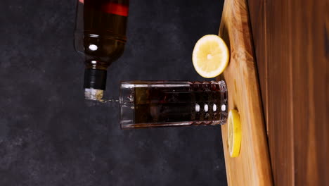 piscola cocktail, typical chilean drink wooden table dark background chile pisco, ice and coke