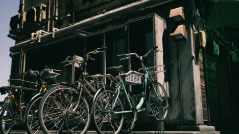 bicycles parked near a building during a sunny day in a vibrant city street