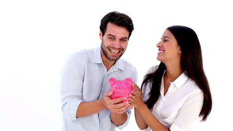 una pareja joven y atractiva con una alcancía.
