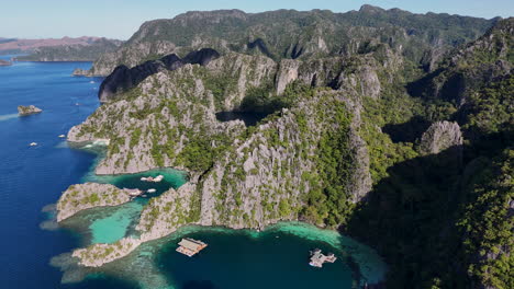 aerial footage of coron island, philippines, showcasing a seamless blend of sparkling waters and verdant tropical terrain. wide revealing aerial shot.