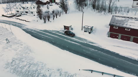 estación de autobuses y automóvil bmw entre estructuras de casas en un paisaje invernal en noruega
